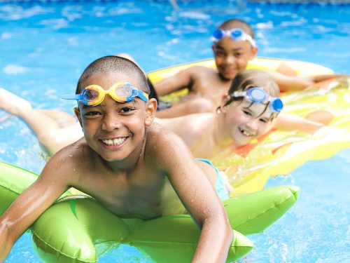 A group of young boys playing in a swimming pool