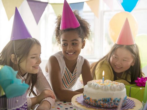 Children gathered around a birthday cake