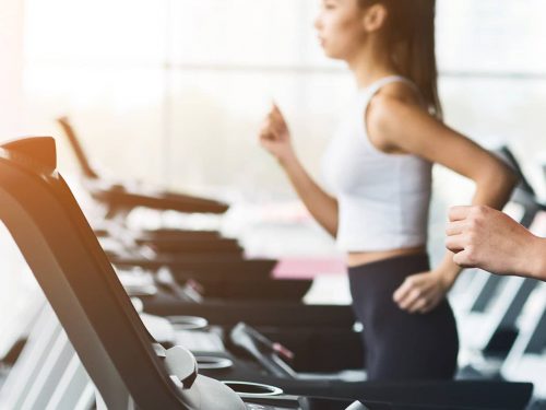 A pair of women jogging on treadmills